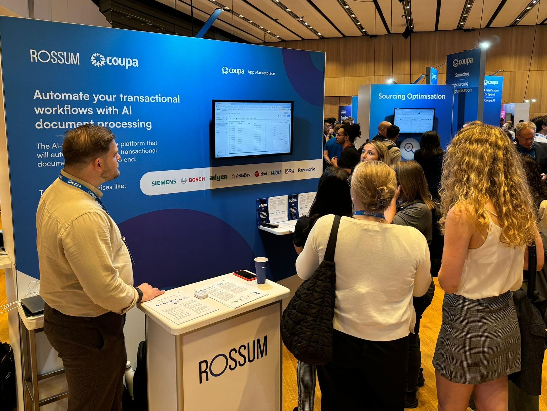Picture of team Rossum standing in front of Rossum's booth at Coupa Inspire EMEA in 2024