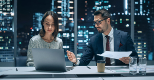 Two professionals using BPO automation on laptop