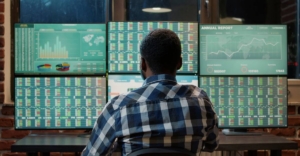 Working capital optimization - person sat in front of multiple computer screens.