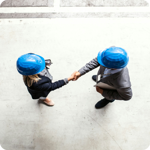 Construction document management software with two people wearing hard hats shaking hands.